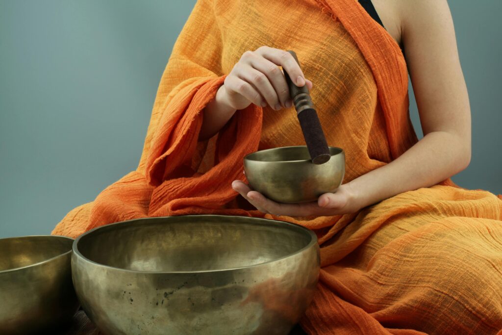 pexels-photo-3544128-3544128 Person in traditional attire using Tibetan singing bowls in a meditative practice.